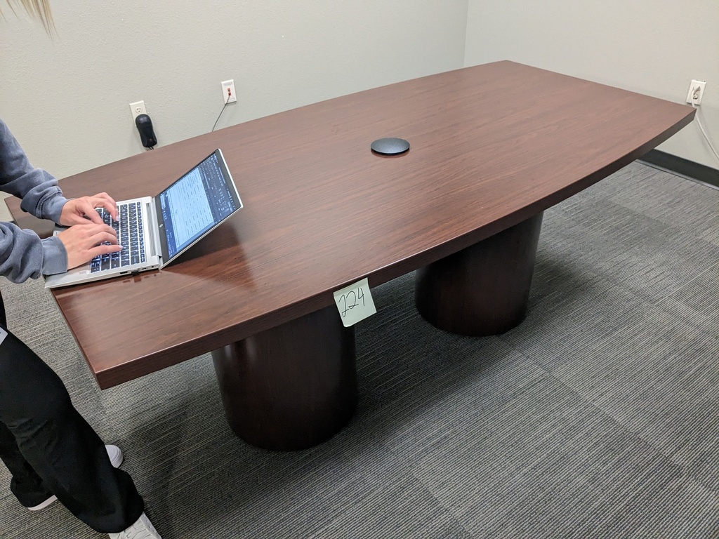 small boat shaped conference table with power and panel bases